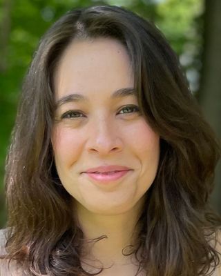 Dr. Jaclin Gerstel-Friedman, licensed psychologist, smiling outdoors in front of green trees.